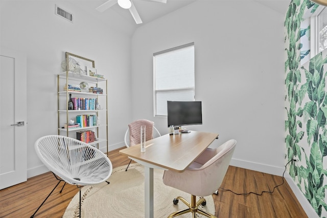 office area featuring wood finished floors, visible vents, baseboards, lofted ceiling, and ceiling fan