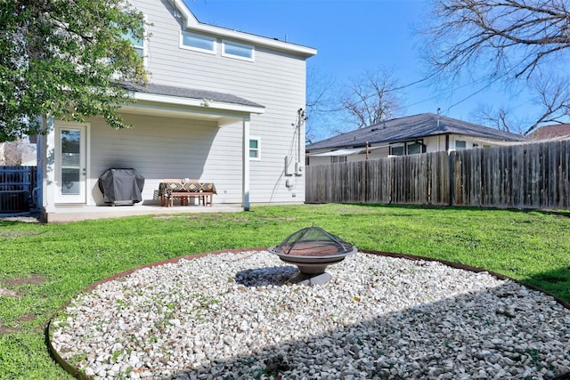 back of property with a patio, a fire pit, fence, and a lawn