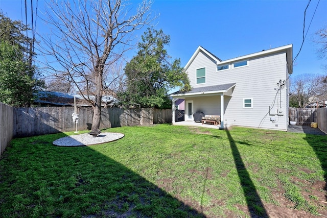 rear view of property with a lawn, a patio, and a fenced backyard