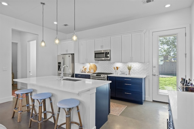 kitchen featuring tasteful backsplash, finished concrete flooring, appliances with stainless steel finishes, blue cabinets, and a sink