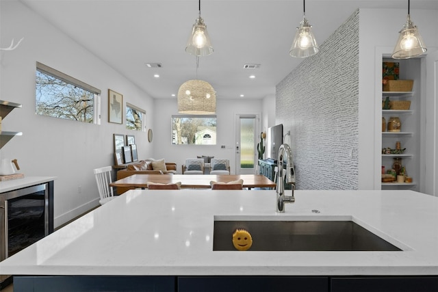 kitchen featuring visible vents, wine cooler, a healthy amount of sunlight, and open floor plan