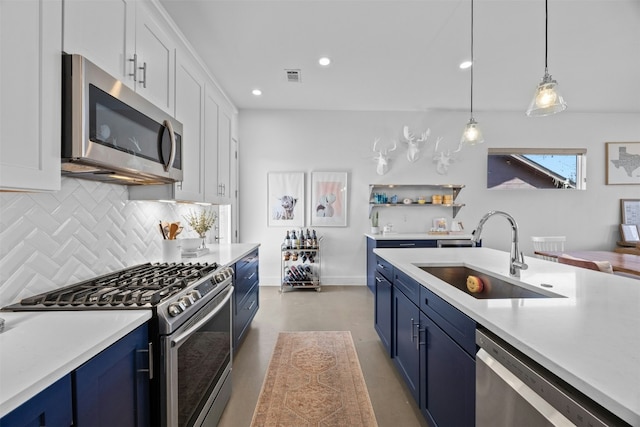 kitchen with blue cabinets, appliances with stainless steel finishes, light countertops, and a sink