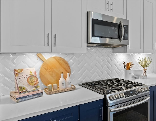 kitchen with white cabinetry, appliances with stainless steel finishes, light countertops, and blue cabinets