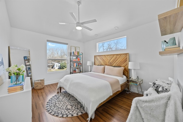 bedroom featuring baseboards, multiple windows, and wood finished floors