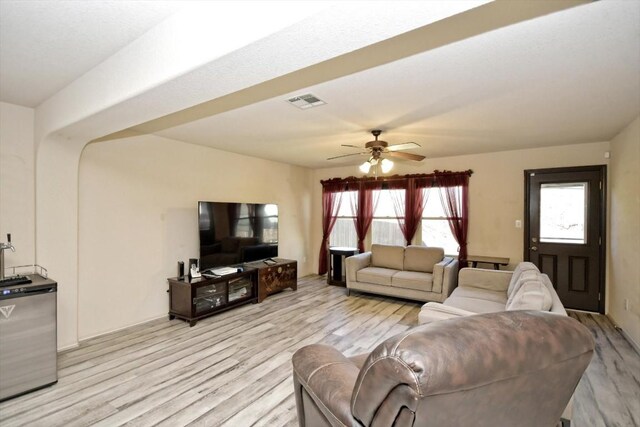 living room with light hardwood / wood-style floors and ceiling fan