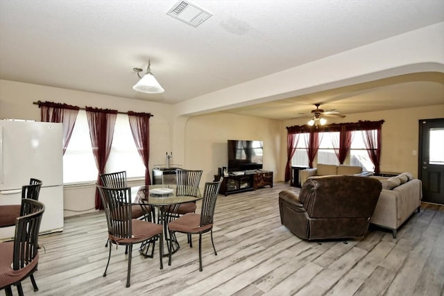 dining room with ceiling fan, light hardwood / wood-style floors, and a healthy amount of sunlight