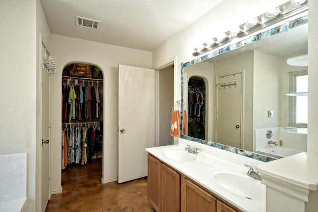 bathroom featuring vanity, concrete flooring, and a bathing tub