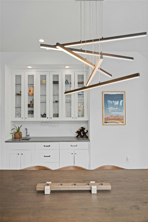 bar with white cabinetry and sink