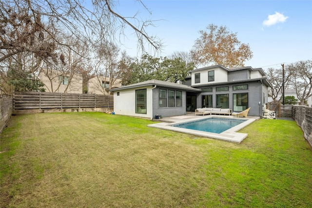 back of property with a fenced in pool, a lawn, and outdoor lounge area