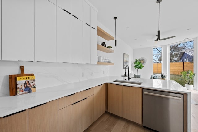 kitchen featuring sink, white cabinetry, decorative light fixtures, dishwasher, and kitchen peninsula