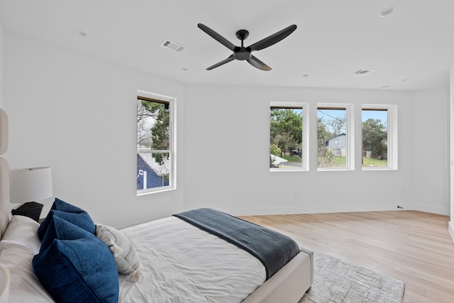 bedroom with multiple windows, ceiling fan, and light wood-type flooring