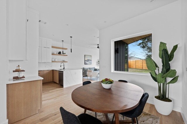 dining space featuring sink and light wood-type flooring