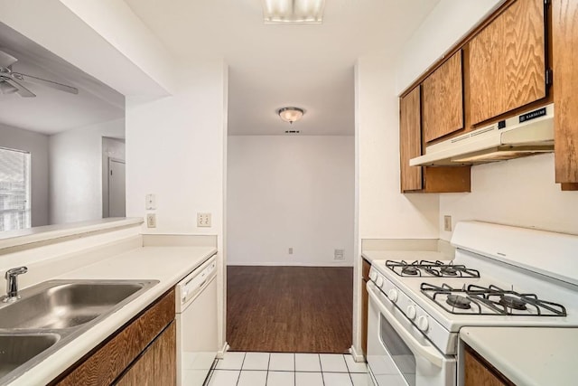 kitchen featuring sink, white appliances, light tile patterned floors, and ceiling fan