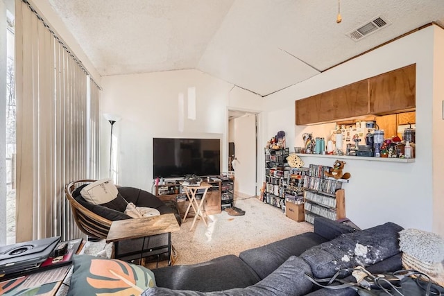 living room with vaulted ceiling, carpet floors, and a textured ceiling