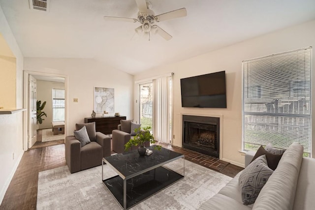 living room featuring dark wood-type flooring, vaulted ceiling, and ceiling fan