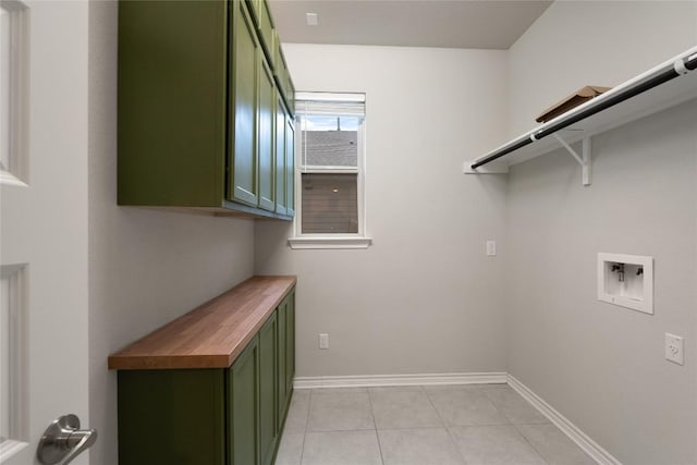 laundry room with washer hookup, light tile patterned floors, and cabinets