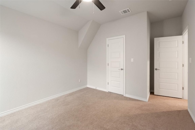 bonus room with ceiling fan and light carpet