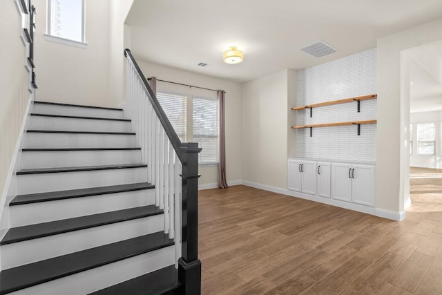 stairway with hardwood / wood-style floors and a wealth of natural light