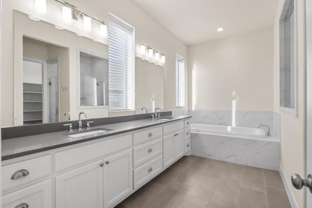 bathroom with tile patterned flooring, shower with separate bathtub, and vanity