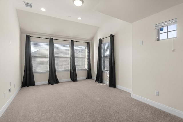 carpeted empty room featuring lofted ceiling