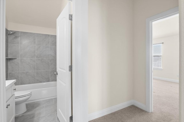 full bathroom featuring vanity, toilet, tiled shower / bath combo, and tile patterned flooring