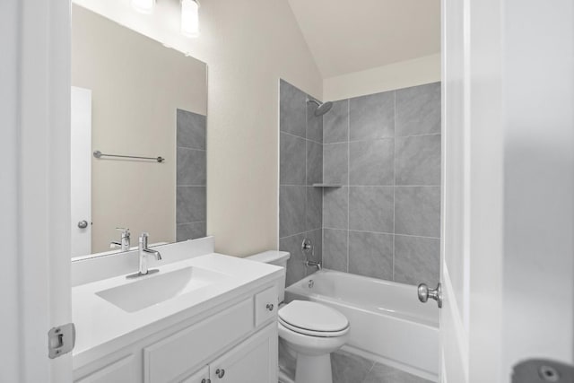 full bathroom with vaulted ceiling, tiled shower / bath combo, vanity, toilet, and tile patterned floors