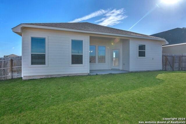 back of property with a yard and a patio area