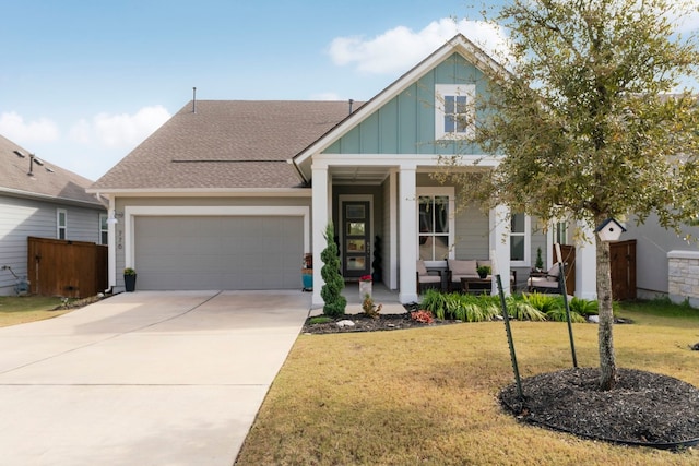 view of front of property with a garage, a front yard, and covered porch