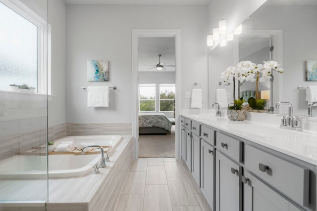 bathroom featuring vanity, tiled bath, tile patterned floors, and ceiling fan