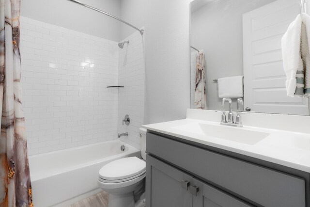 full bathroom featuring vanity, shower / bath combination with curtain, and toilet