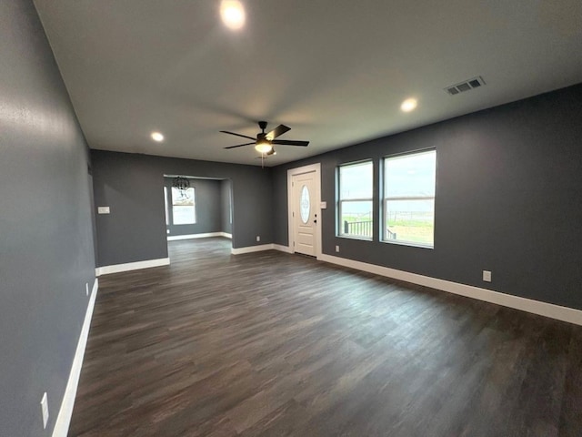 spare room with ceiling fan, dark wood-type flooring, and a healthy amount of sunlight