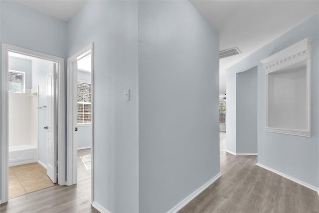 hallway with light hardwood / wood-style floors