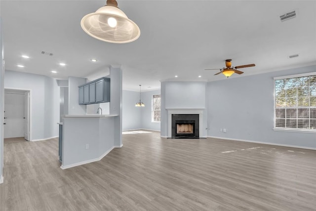 unfurnished living room with ceiling fan and light hardwood / wood-style flooring