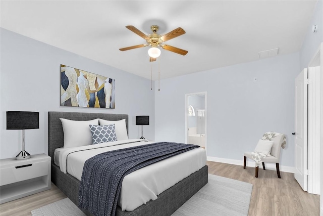 bedroom featuring ceiling fan, ensuite bathroom, and light wood-type flooring