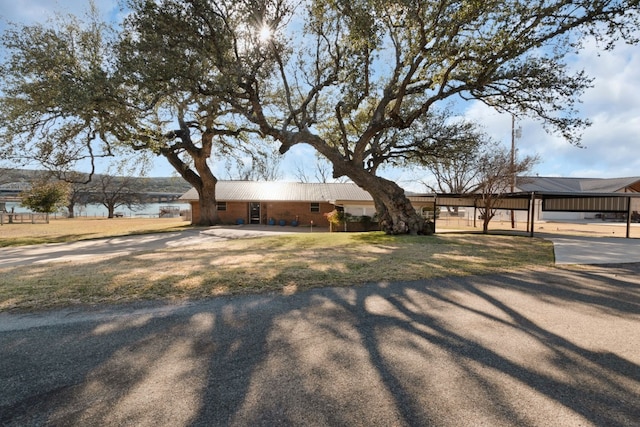 single story home with a water view and a front lawn