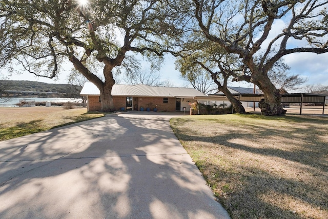 ranch-style home with a water view and a front lawn