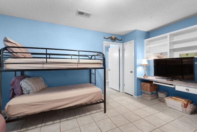 tiled bedroom featuring a textured ceiling