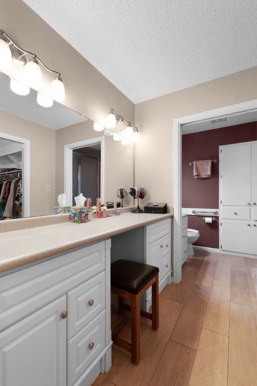 bathroom featuring vanity, hardwood / wood-style floors, and a textured ceiling