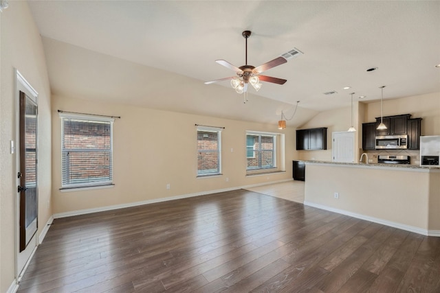 unfurnished living room with vaulted ceiling, dark hardwood / wood-style floors, and plenty of natural light