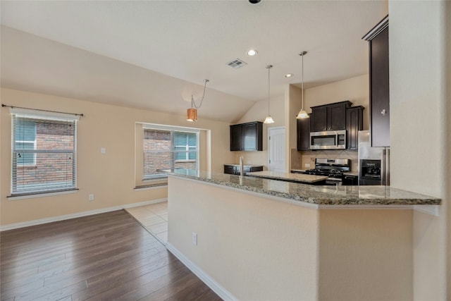 kitchen featuring stainless steel appliances, light stone countertops, hanging light fixtures, and kitchen peninsula