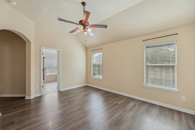 unfurnished room featuring ceiling fan, vaulted ceiling, and dark hardwood / wood-style flooring