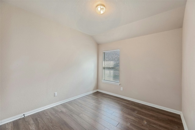 spare room with lofted ceiling and dark hardwood / wood-style floors