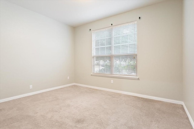 spare room featuring light colored carpet