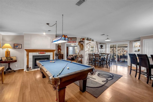 playroom featuring pool table, a tile fireplace, and light wood-type flooring