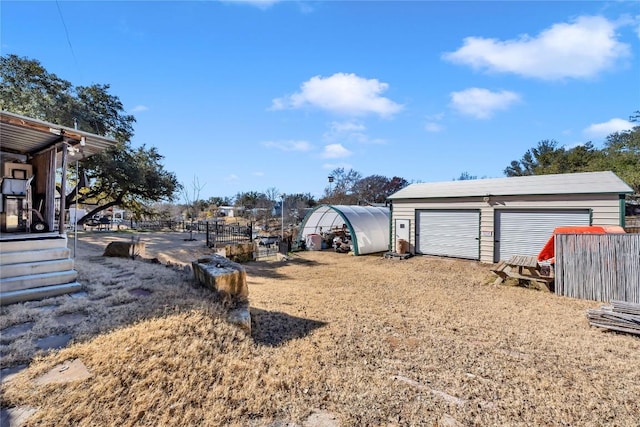 view of yard featuring a garage and an outbuilding