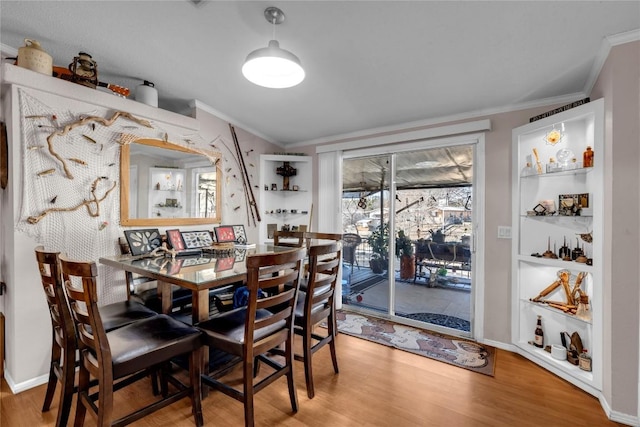 dining space featuring crown molding and hardwood / wood-style floors