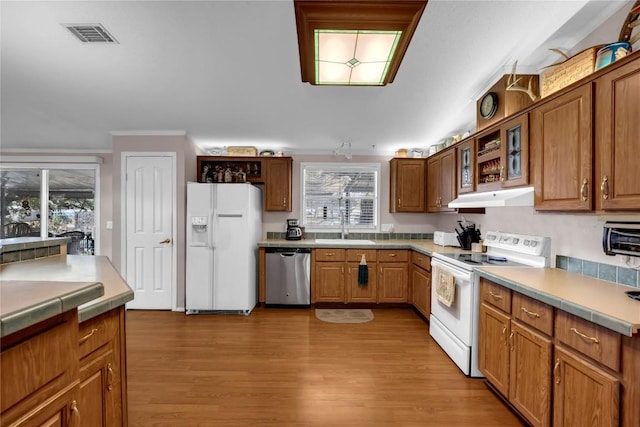 kitchen with a healthy amount of sunlight, sink, white appliances, and light hardwood / wood-style floors