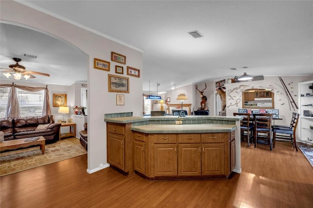 kitchen featuring hardwood / wood-style floors, crown molding, and ceiling fan