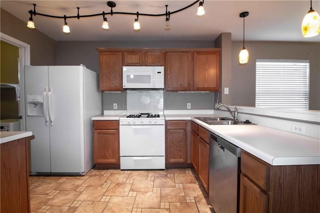 kitchen featuring pendant lighting, sink, white appliances, and backsplash