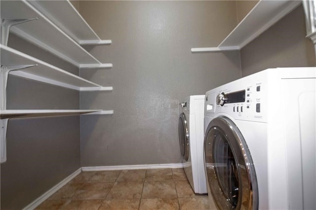 clothes washing area featuring washer and dryer and tile patterned floors